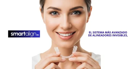 Paciente sonriendo mientras sostiene un alineador invisible SMARTalign